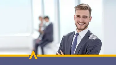 Uśmiechnięty mężczyzna w garniturze w nowoczesnym jasnym biurze